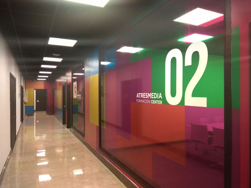 Instalación de vinilos ultracristalinos de colores en cristaleras de oficinas Atresmedia
